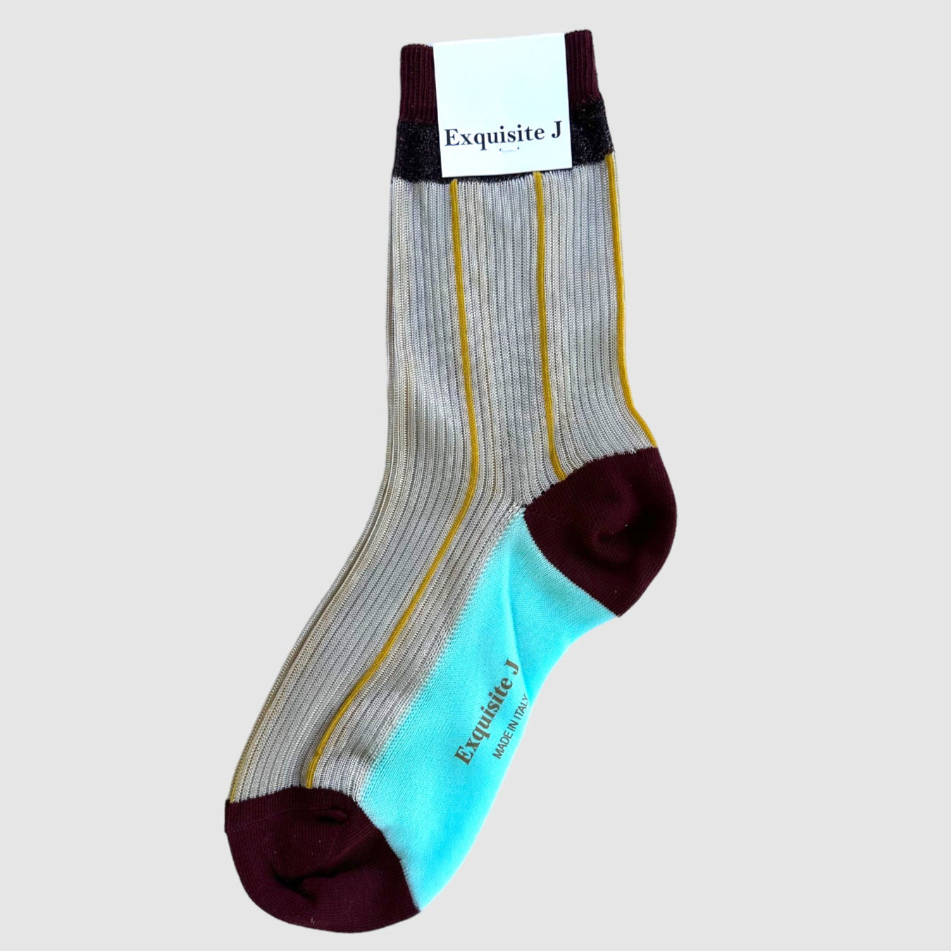 A pair of dress socks with a sheer cream and gold design, featuring solid turquoise and scarlet at the toe and heel areas.