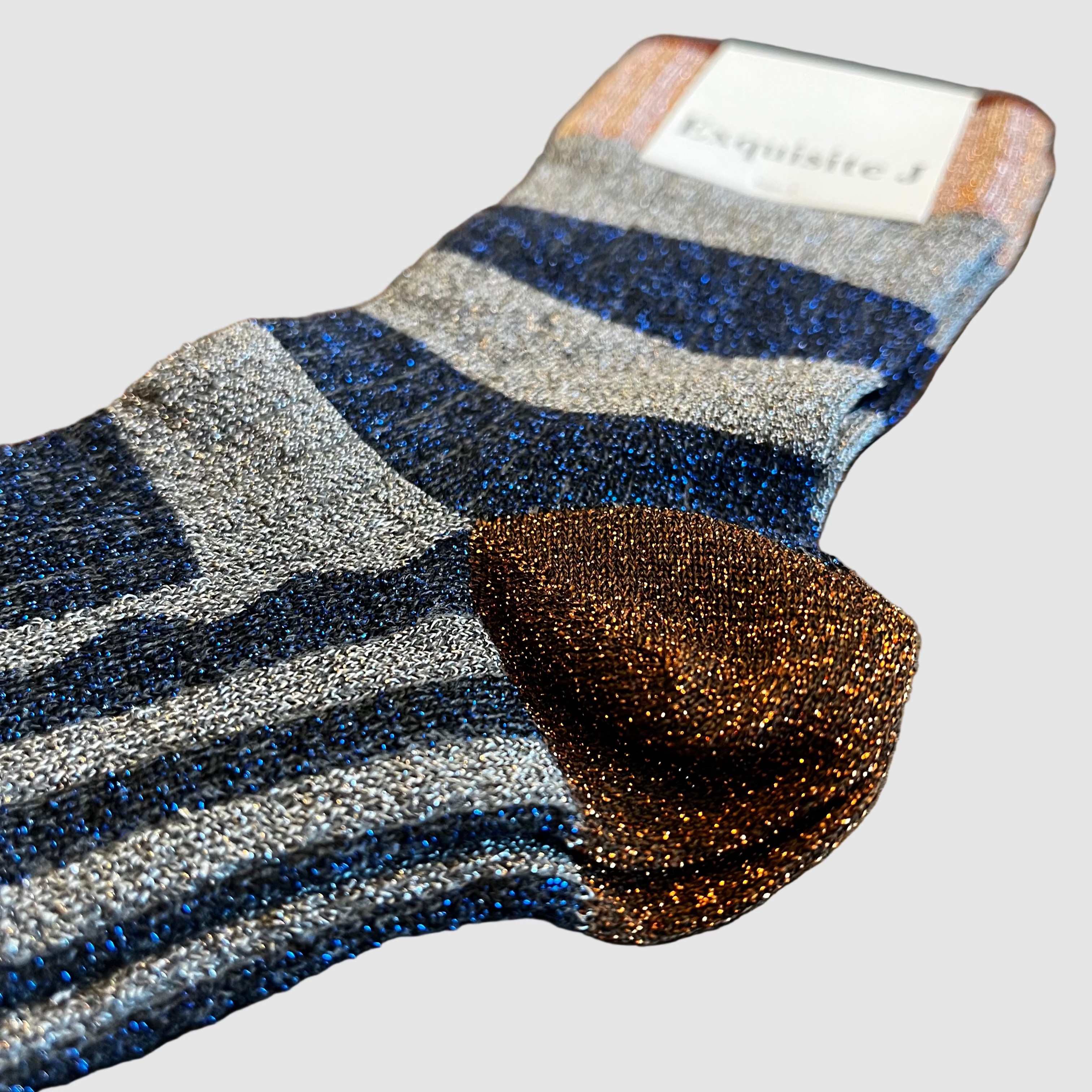 Pair of striped socks on a wooden surface with a brand label visible.