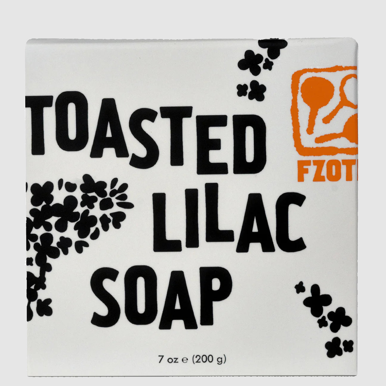 Box of Handmade Toasted Lilac Bar Soap from FZOTIC with black text and floral designs on a light grey background