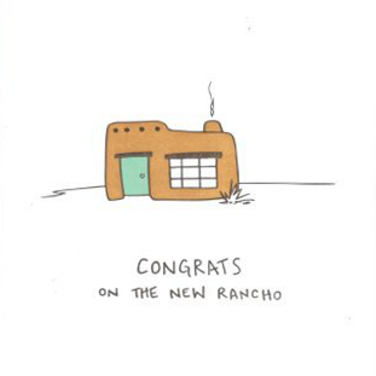 Greeting card with a cartoon house and 'Congrats on the new Rancho' text, framed in brown paper.