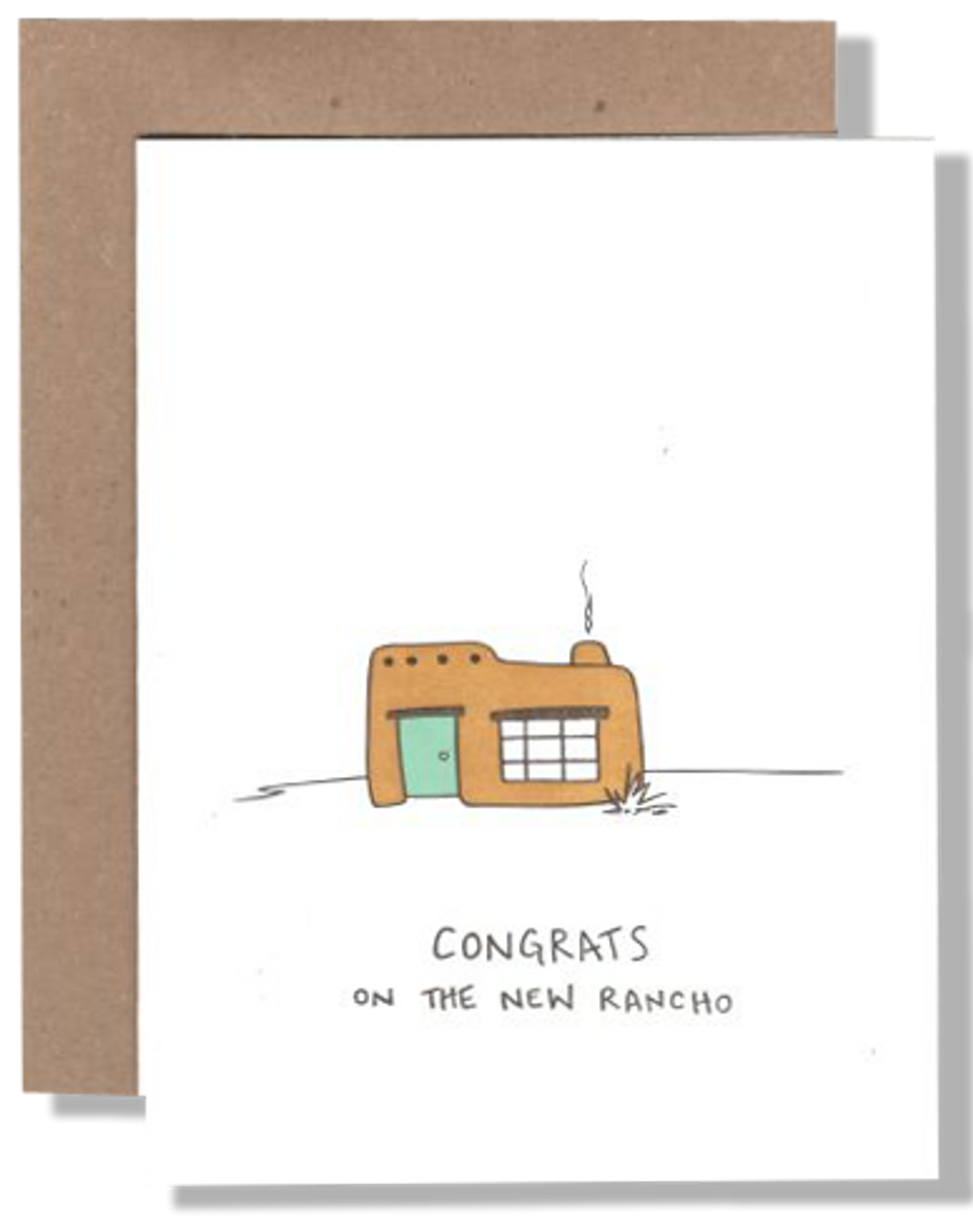 Greeting card with a cartoon house and 'Congrats on the new Rancho' text, framed in brown paper.