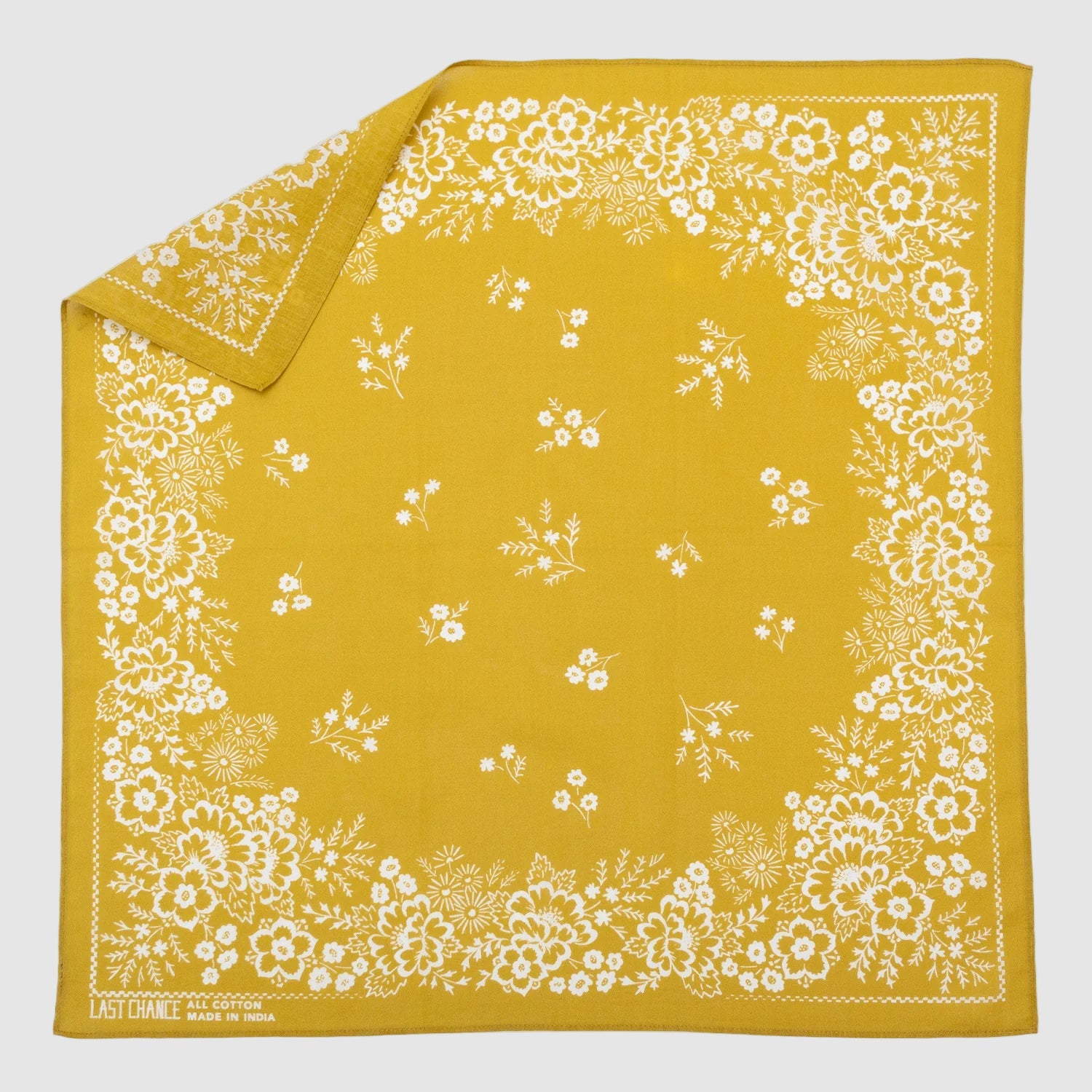 Yellow Last Chance Textiles bandana with white floral pattern on a gray background