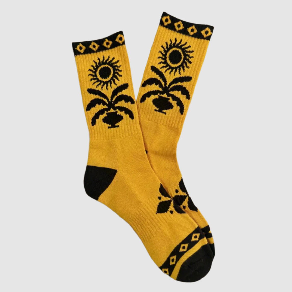 Yellow socks with black floral patterns on a beige background