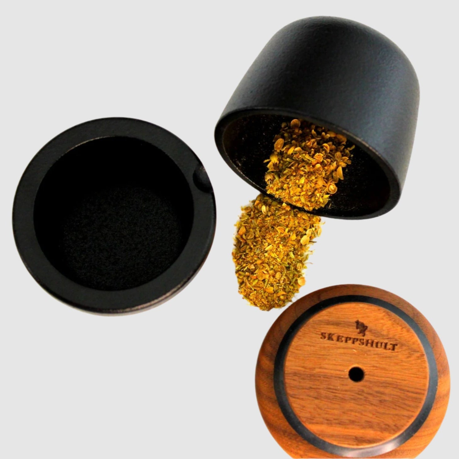 Black herb grinder with wooden base and 'Skeppshult' branding on a white background
