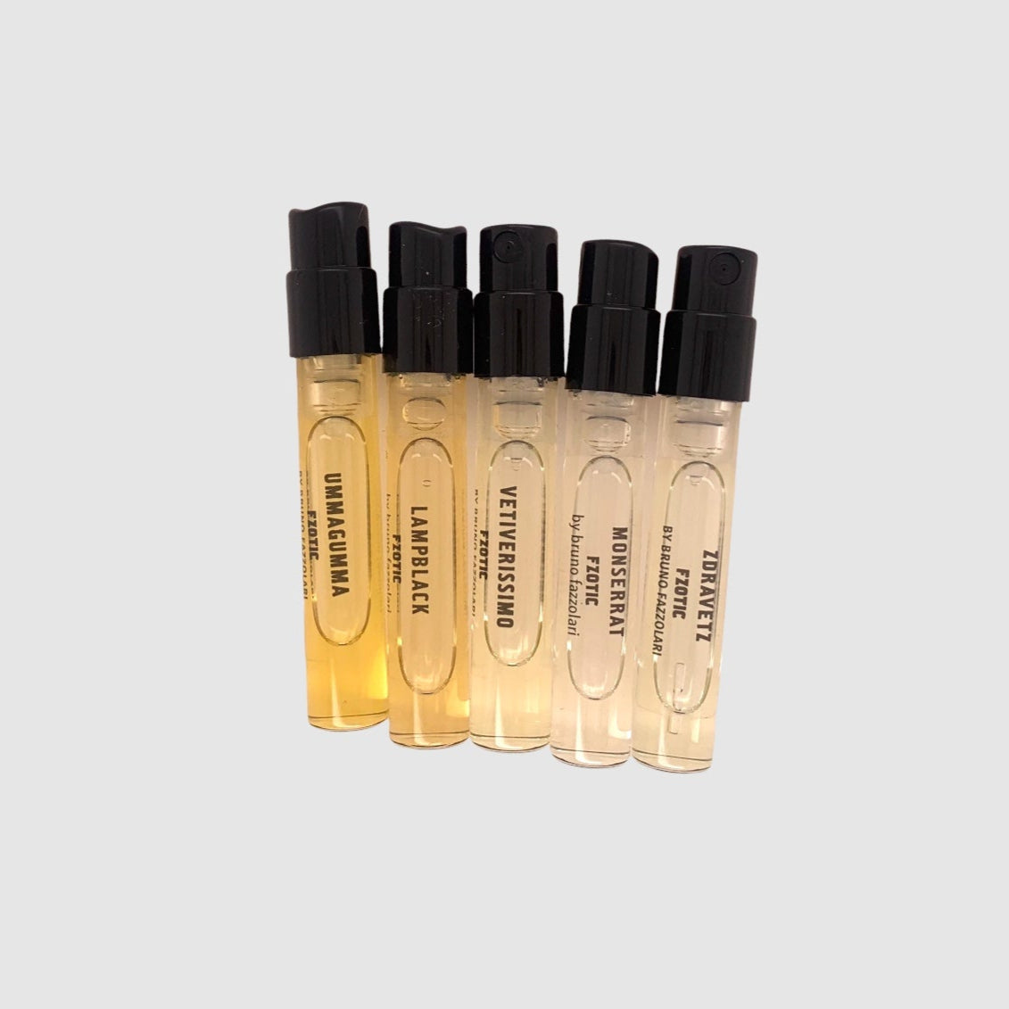 A set of five small, clear glass bottles with black caps, labeled as different samples from the FZOTIC PORTFOLIO.