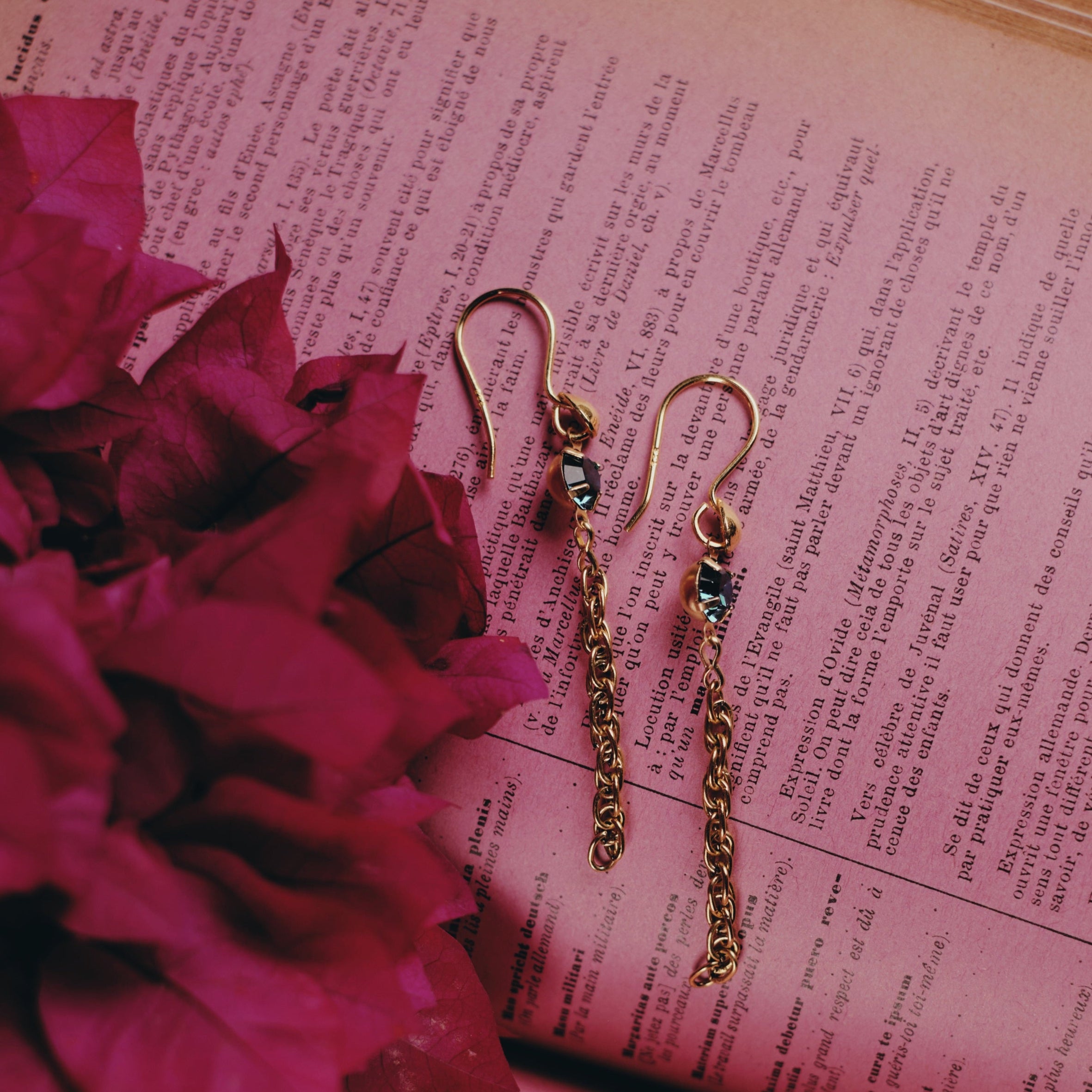 vermeil french wires with swarovski crystal drop and brass chain drop earrings handmade in Tucson by Tasha Bundy sitting on a book with some pinkish tint