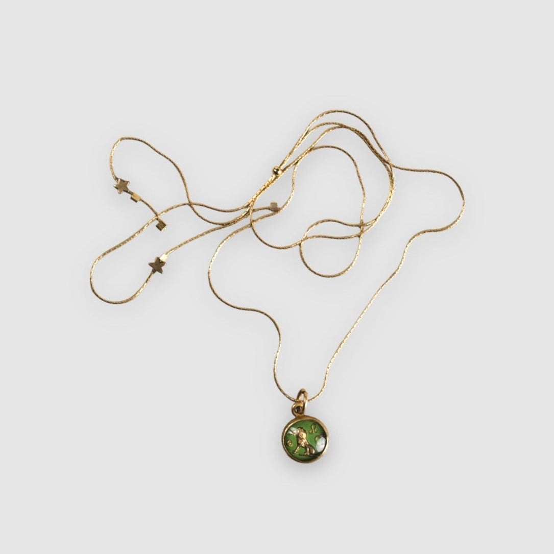 Gold necklace with a green pendant on a white background