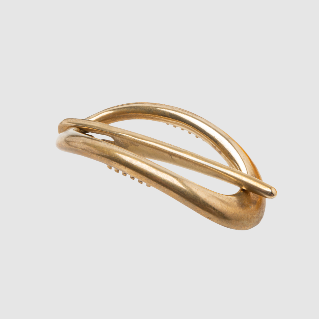 A single bronze Danish hair clip on a light grey background