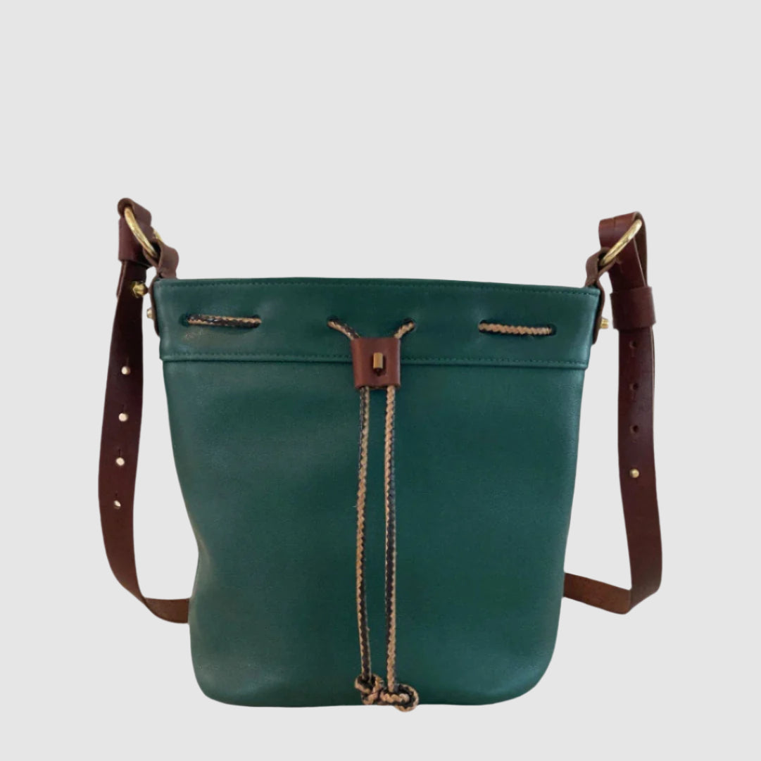 Green leather handbag with brown straps on a light gray background